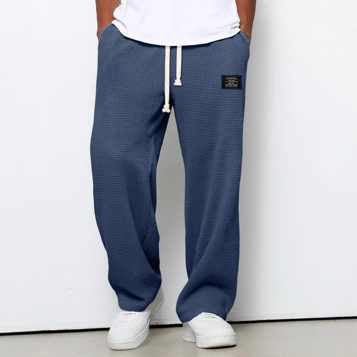 Folded Men's Stuart wide leg chino pants, showcasing the comfortable, relaxed fit & durable material.