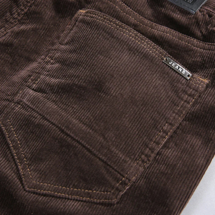 Dark grey men's corduroy trousers with a refined tailored fit, perfect for versatile winter outfits.