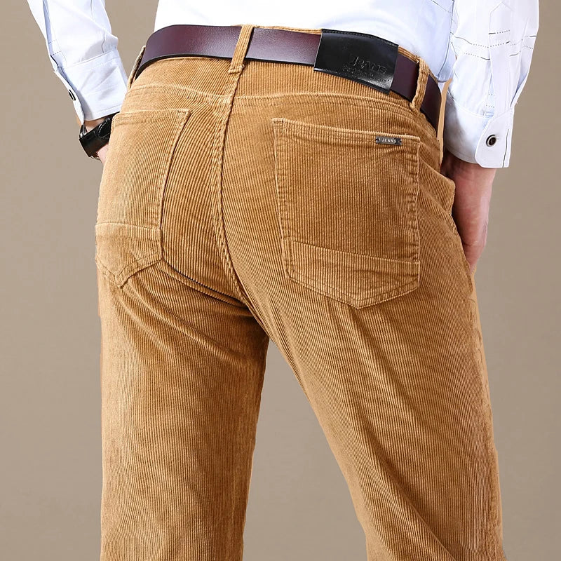 Detail of the waistband and button closure on men's tailored corduroy dress trousers, quality design.