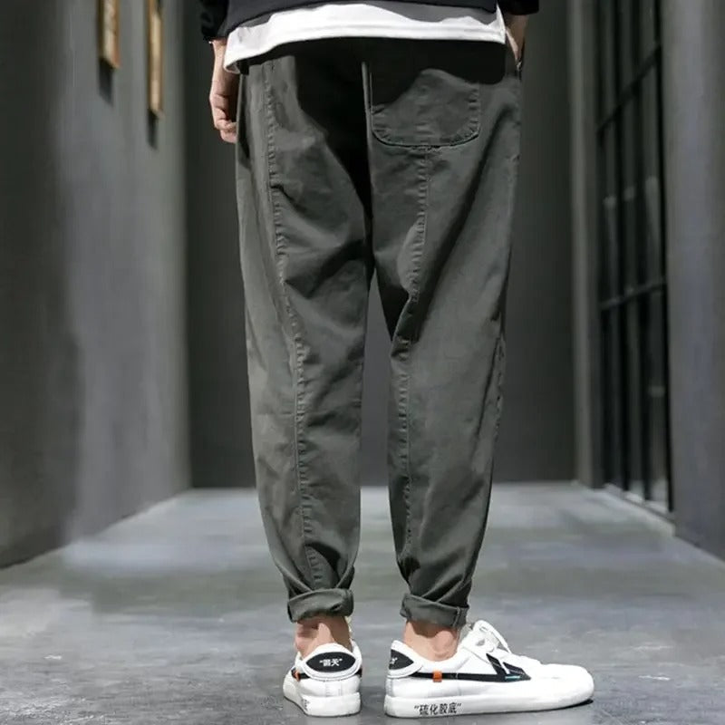 Man performing a stretch in men's tapered joggers, emphasizing the flexibility for everyday comfort.