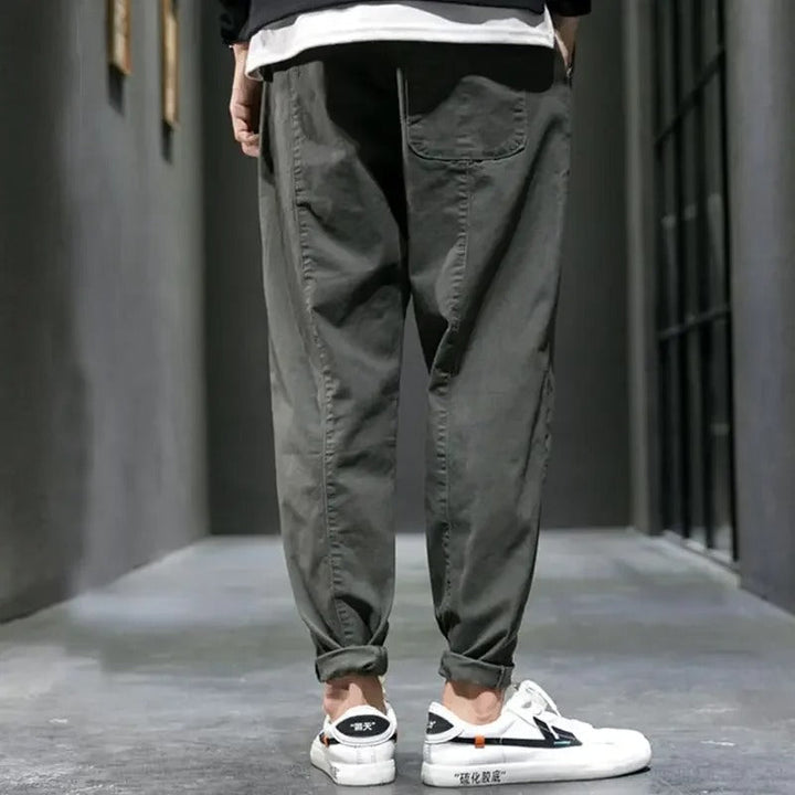 Man performing a stretch in men's tapered joggers, emphasizing the flexibility for everyday comfort.