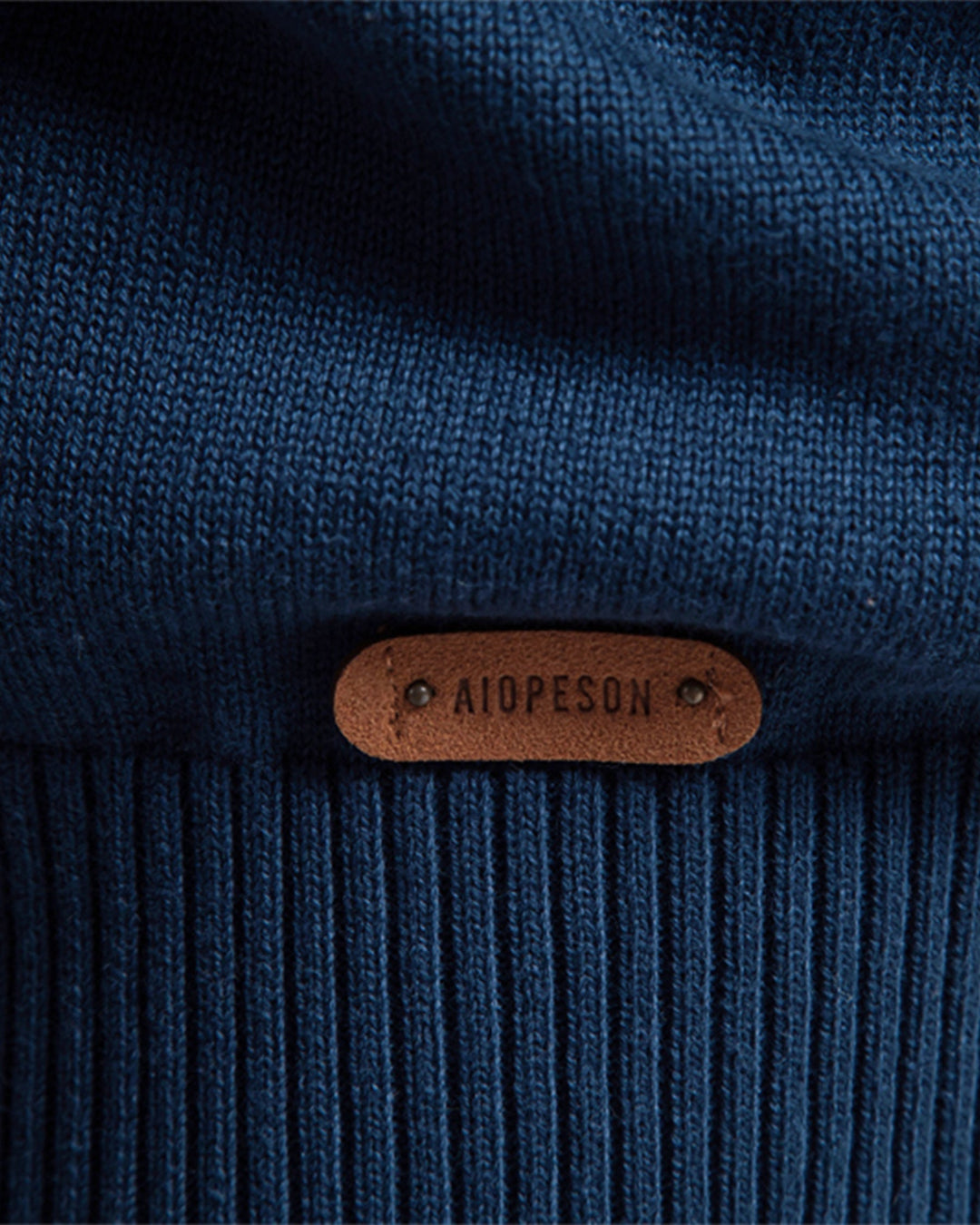 Textured knit pattern detail on a men's crew neck pullover, indicating premium quality