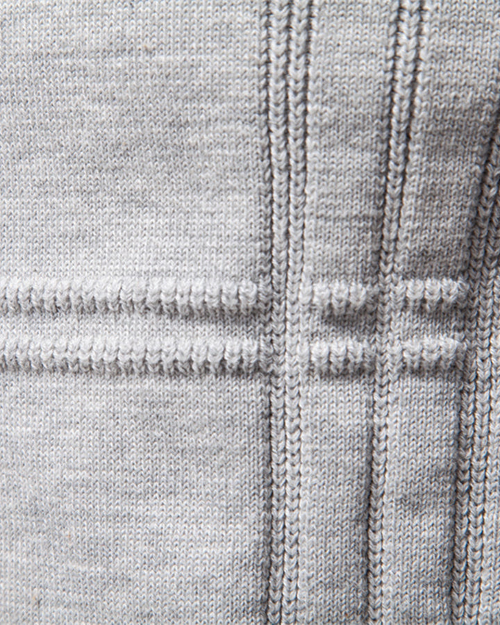 Men's fashion staple: a blue textured knit crew neck pullover draped over a chair