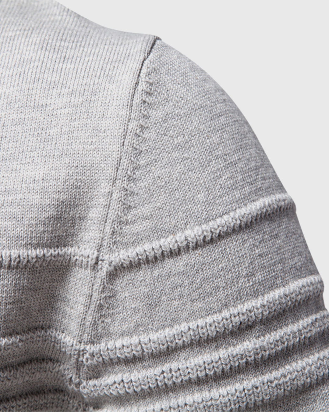 Detail of the hemline on a men's everyday textured crew neck sweater