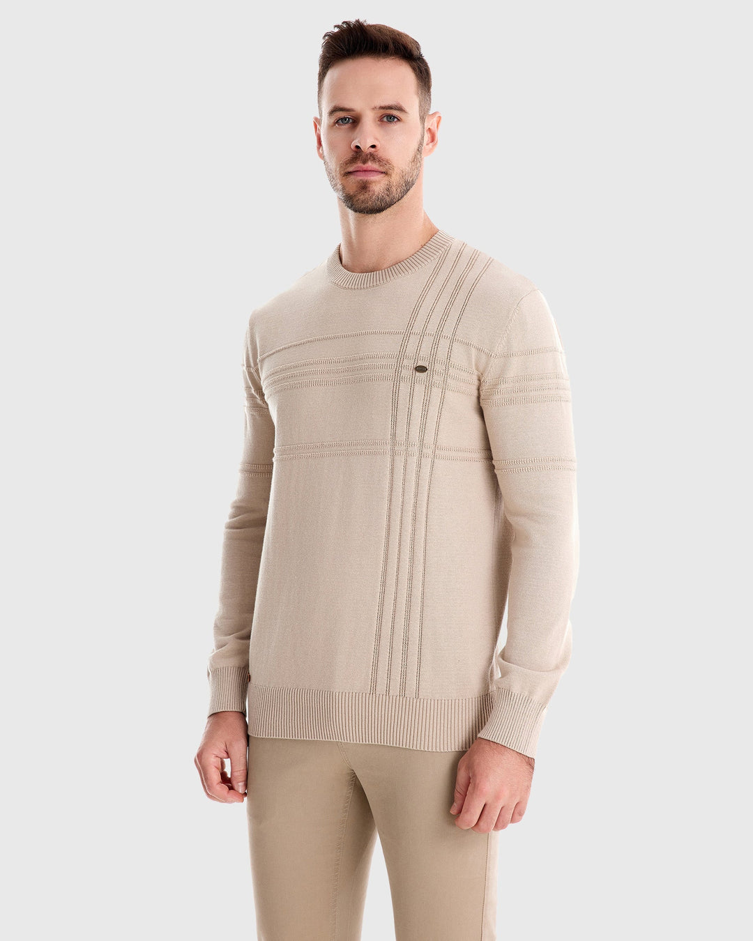 Man in a textured crew neck sweater, hands in pockets, exuding casual confidence