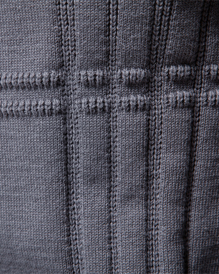 Man's arm in a textured crew neck sweater, highlighting the quality knit