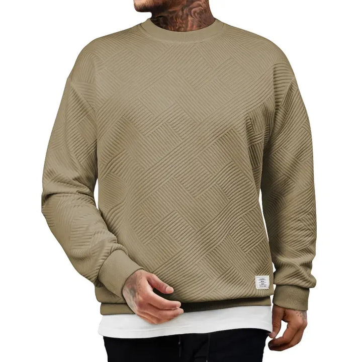 Full shot of a man wearing a cream textured knit pullover sweater, showcasing its casual fit.