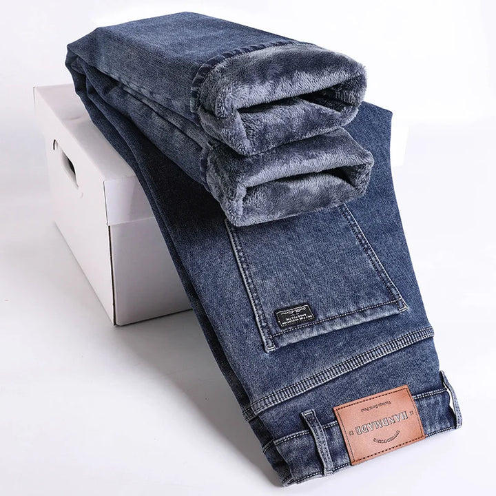 Detail of the waistband and button on men's thermal slim fit jeans. Comfortable stretch denim.