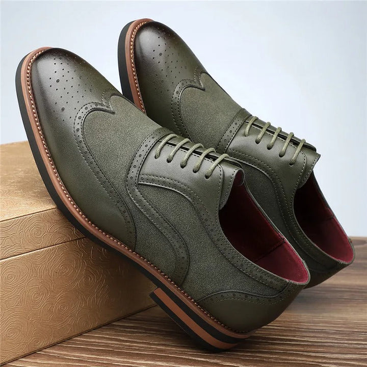 High-angle shot of men's two-tone wingtip brogue oxfords on a wooden surface