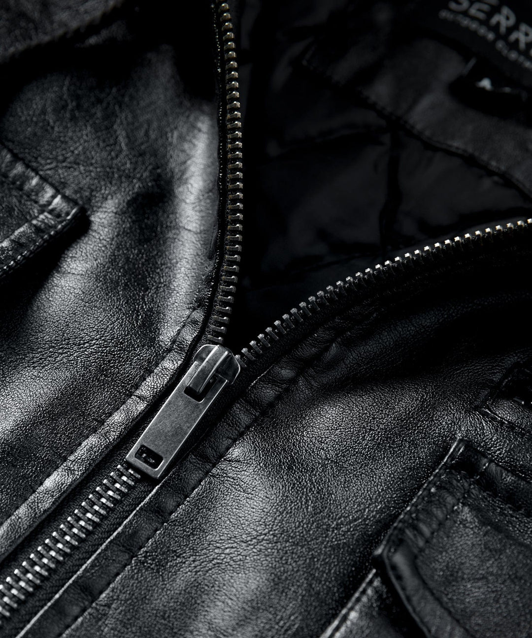 Detail of the robust zipper closure and pockets on the Men's Urban Edge Faux Leather Jacket for practicality