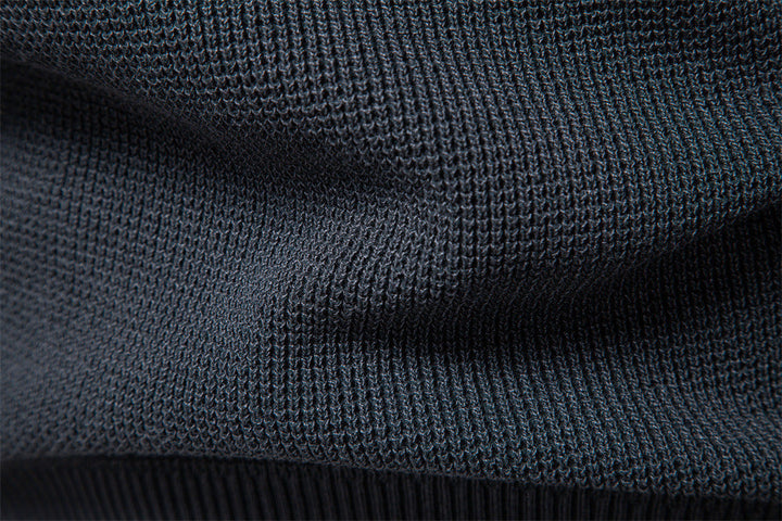 Close-up of the cuff on a men's waffle knit pullover, showcasing fine knitwear detail.