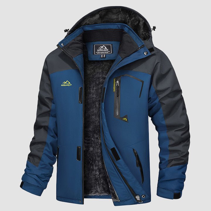 Man wearing blue waterproof ski jacket, side profile, skiing down a slope.