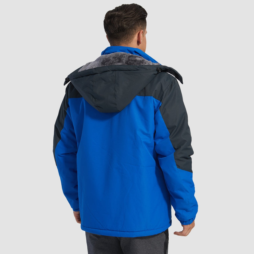 Hood cinched tight on men's blue ski jacket, protecting from blizzard.