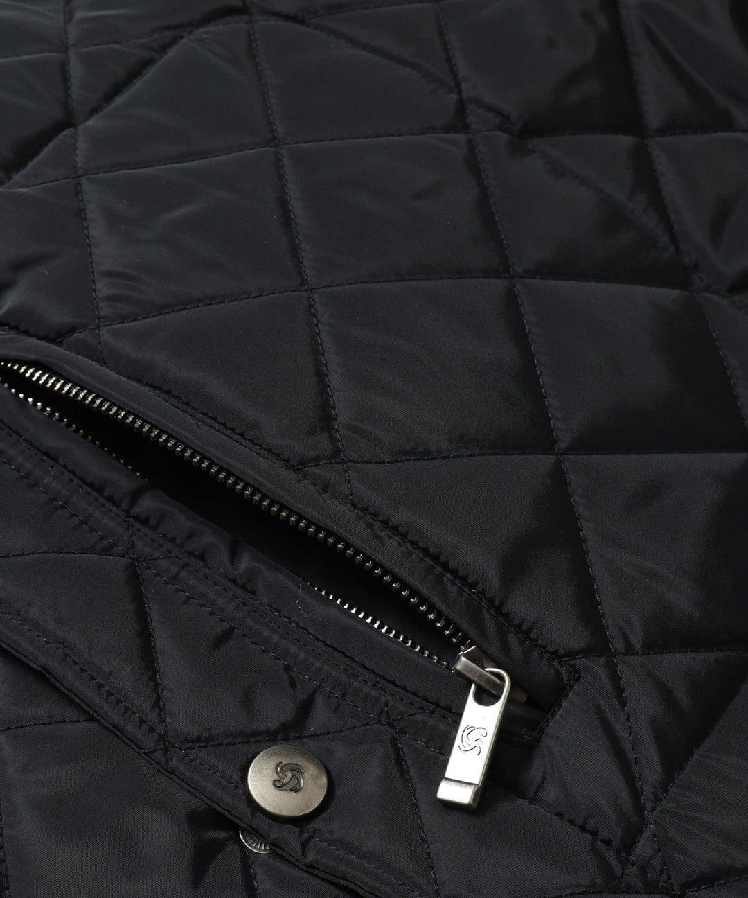 Detail shot of the quilted pattern on a women's vest, emphasizing texture and quality outerwear.