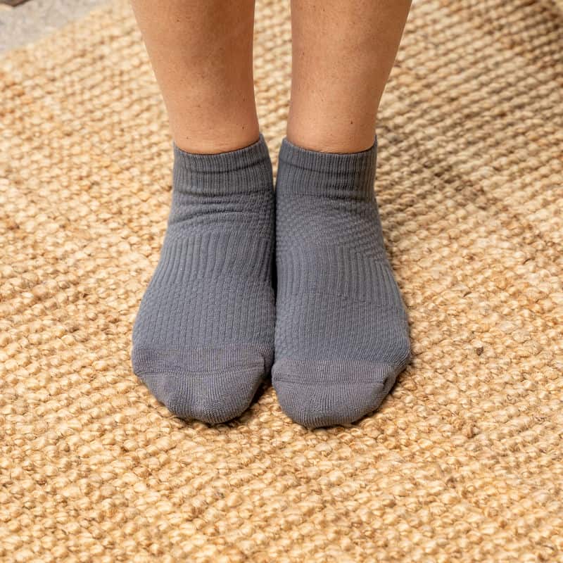 Close-up of a gray compression sock, highlighting the ankle support and comfortable fabric.