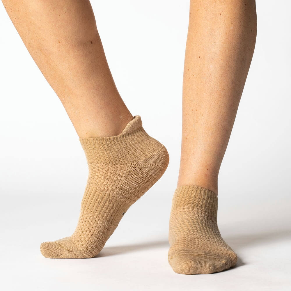 Close-up of a tan ankle compression sock, showcasing its gentle support and comfortable design.