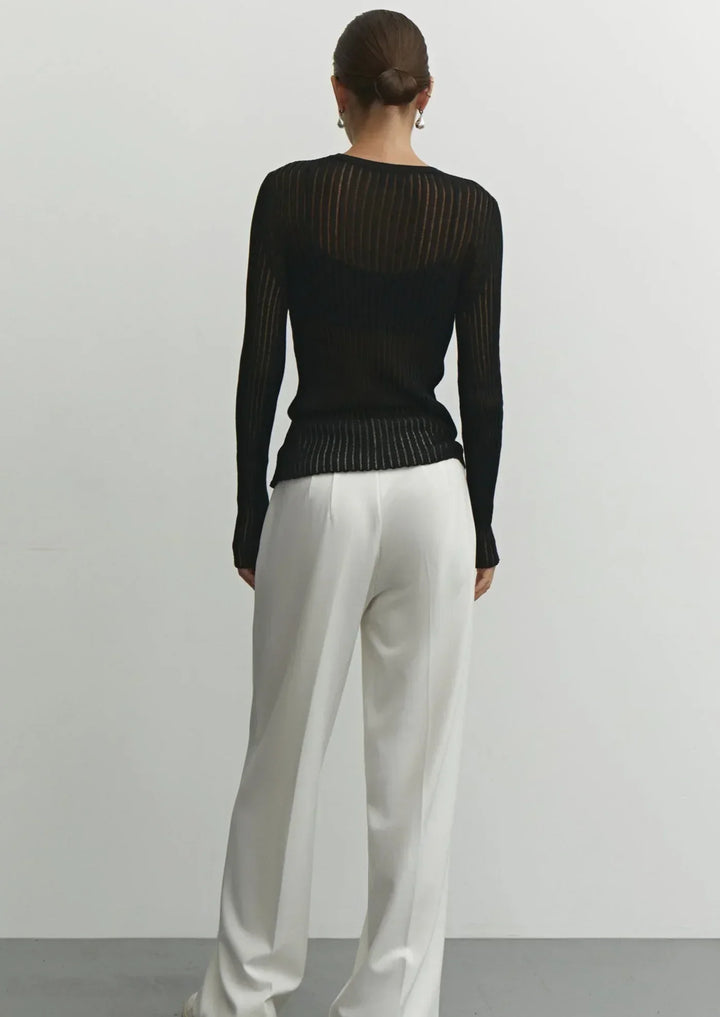 Close-up of sheer ribbed long sleeve top texture. Women's elegant & modern apparel, perfect for chic versatile style.