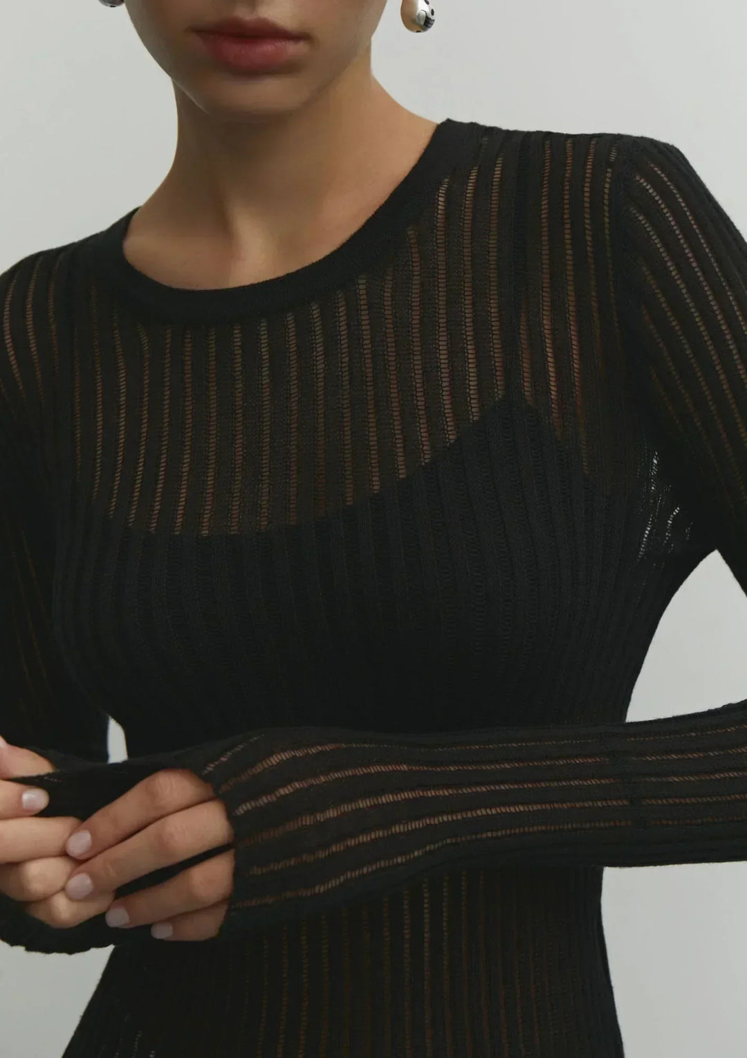Model wearing women's sheer ribbed long sleeve top casually. Effortless, comfortable, and chic day wear.