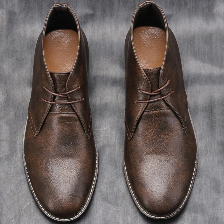 Rugged men's dark brown leather ankle boots, isolated on white background, product shot
