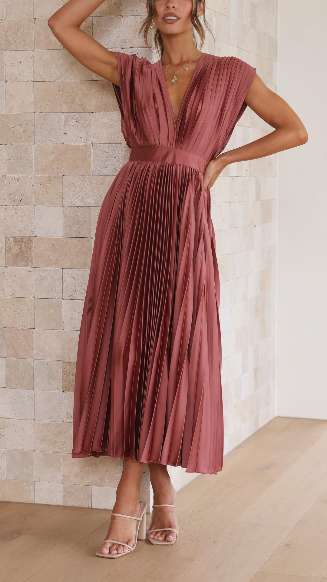 Silk pleated maxi dress with V-neck in rose red, featuring a high waist and elegant flowing pleats for a sophisticated look.