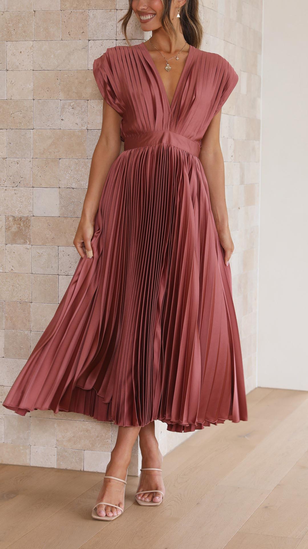 Silk pleated maxi dress with V-neck in rose red, featuring a high waist and elegant flowing pleats for a sophisticated look.