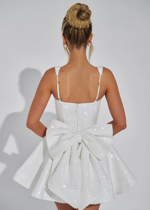 Fashionable women's sparkling mini dress featuring a backless cut & elegant bow. Ideal for evening glamour.