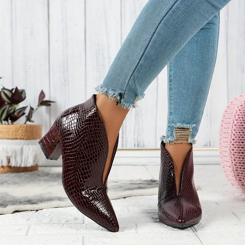 Dynamic shot of women's reptile print ankle boots, highlighting their stylish and chic design.