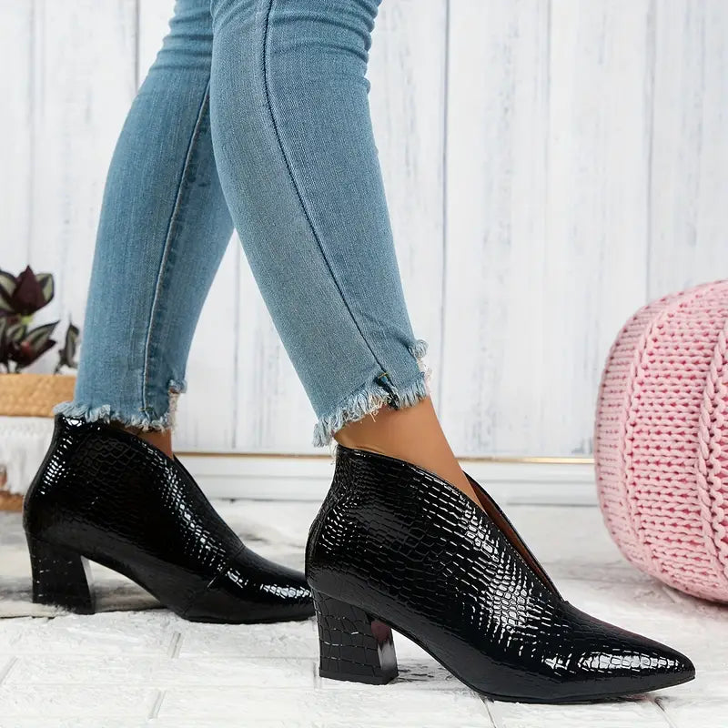 Group of women's ankle boots with reptile print, demonstrating various angles and stylish features.