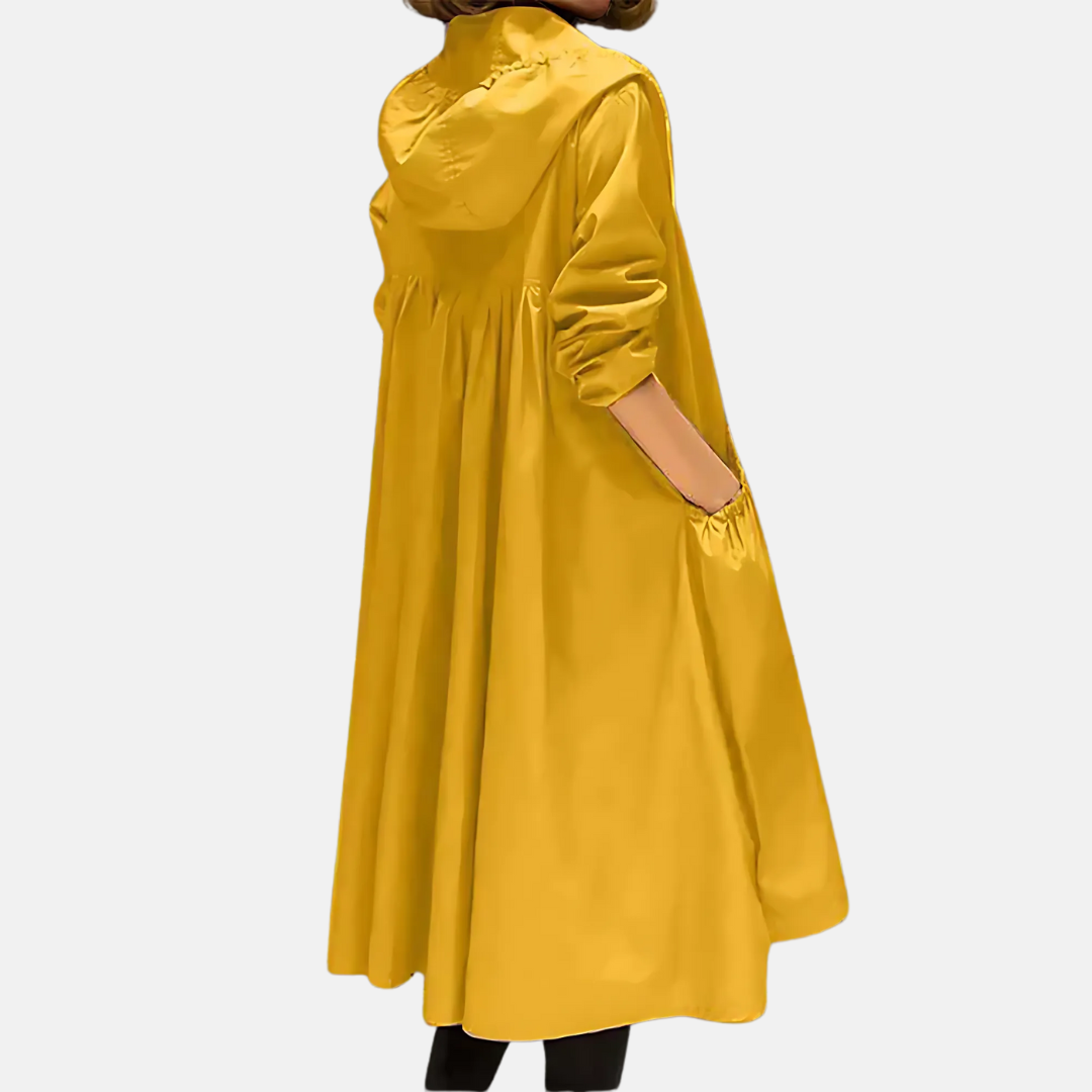 Side view of a woman in a knee-length hooded rain jacket, offering water-resistant protection for autumn outings.