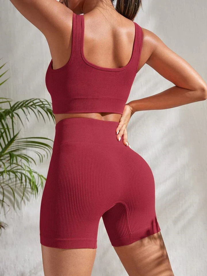 Comfortable women's yoga outfit: high-waist athletic shorts & supportive sports bra crop top for flexibility.