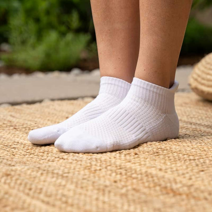 Close-up of white unisex ankle compression sock, highlighting soft fabric and gentle compression