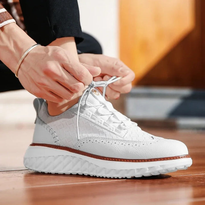 Bottom sole of a white athletic sneaker, revealing traction pattern for stability.