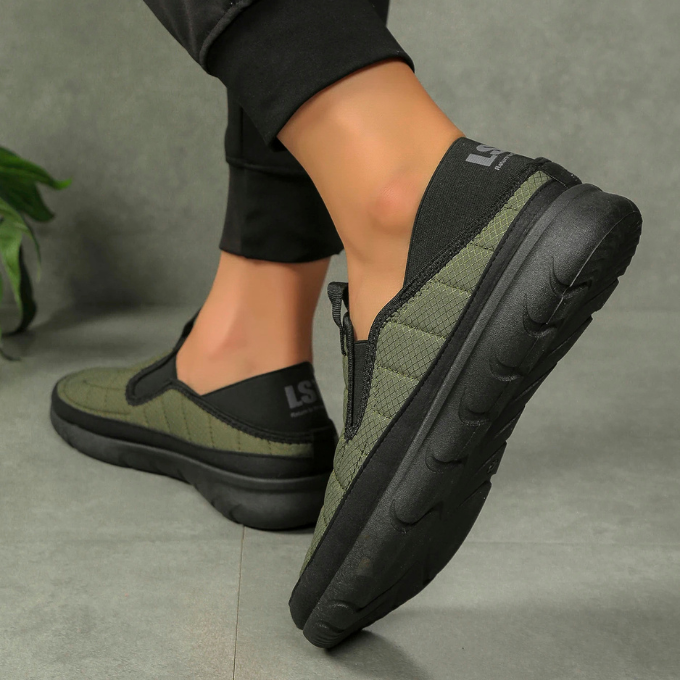 Side profile of a unisex blue slip-on comfort shoe, highlighting its casual style and comfort features
