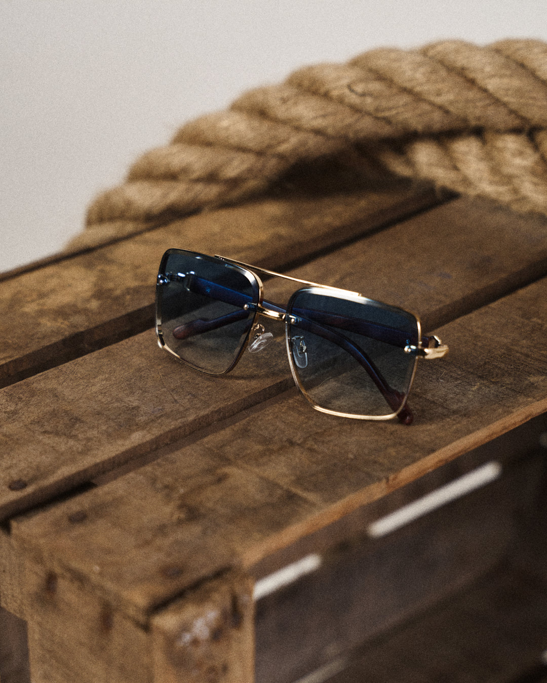 Unisex fashion eyewear: bold square sunglasses with a gold frame and elegant wooden arms.