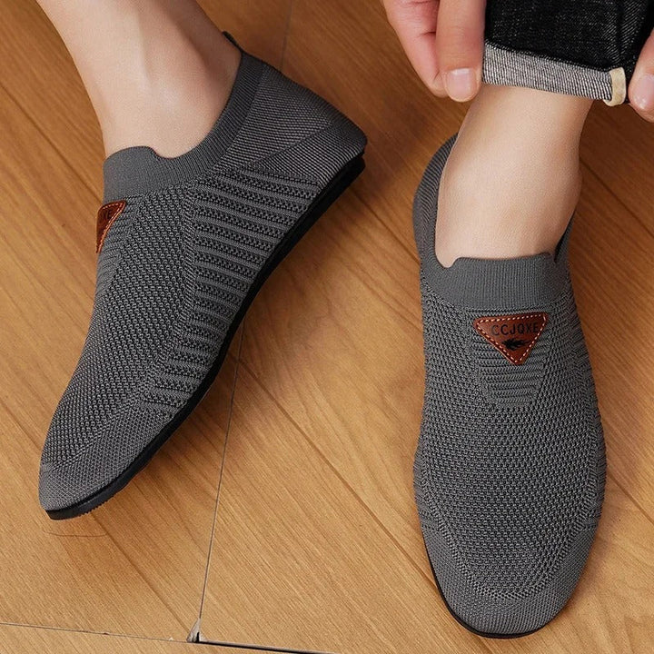 Model wearing Unisex Breathable Knit Comfort Slip-On Shoes, demonstrating casual style.