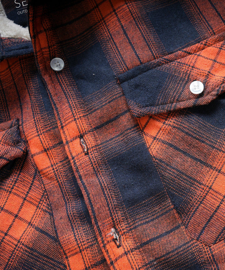 Detail shot of the buttons on a classic plaid flannel shirt jacket, unisex appeal.