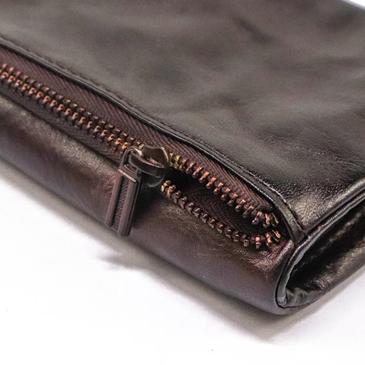 Hand holding a distressed leather snap-closure wallet, showing size & feel