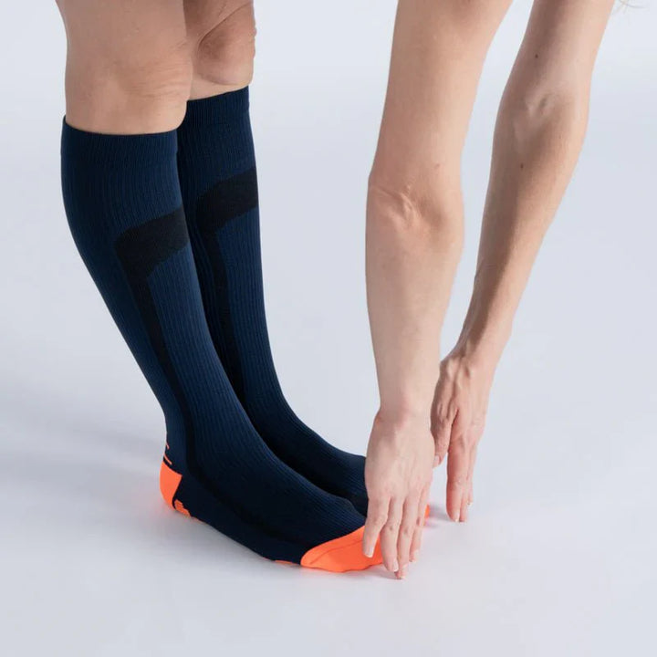 Pair of athletic blue and orange compression socks, designed for unisex gentle support and footwear comfort