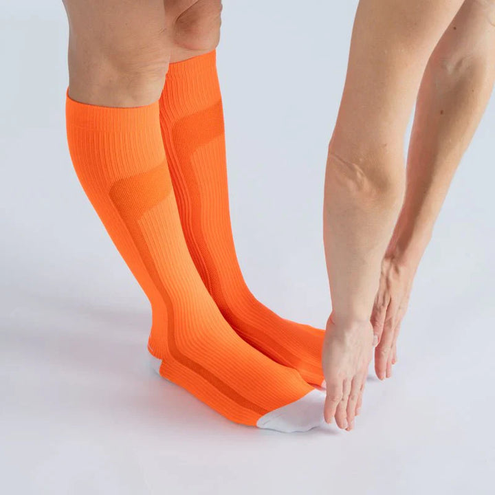 Pair of orange-vanilla compression socks, perfect for travel, athletics, or daily comfortable wear