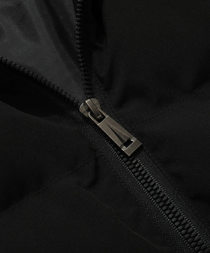 Model wearing a unisex insulated puffer vest with hood over a sweater, showcasing layering capabilities.