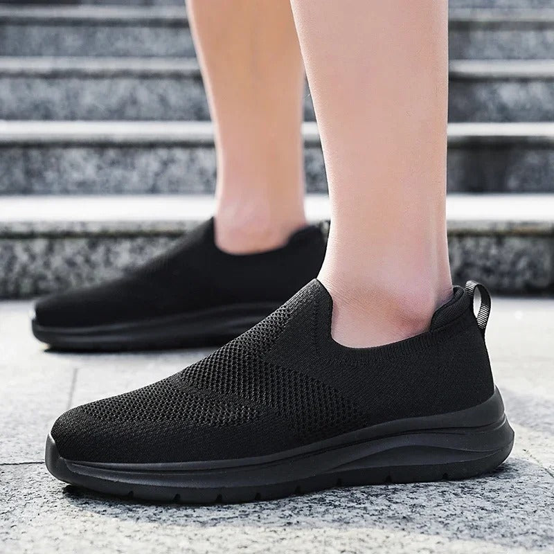 Close-up of the knit texture on a grey unisex slip-on sneaker, showing its breathable design.