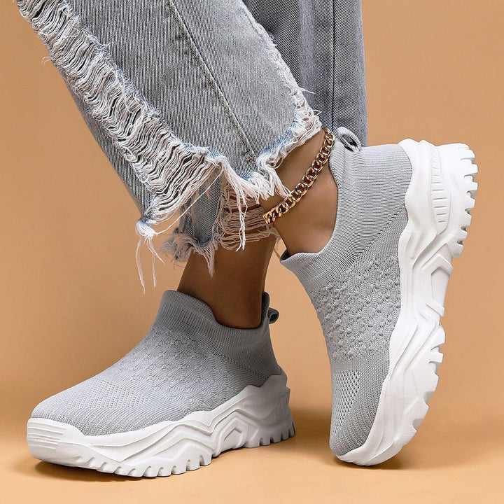 Detail of the sole of gray and white orthopedic cloud slip-on shoes, showing traction and support