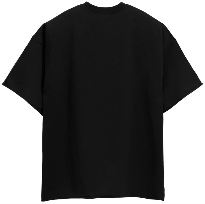 Model wearing an oversized black cotton tee with drop shoulders, ideal unisex casual apparel.