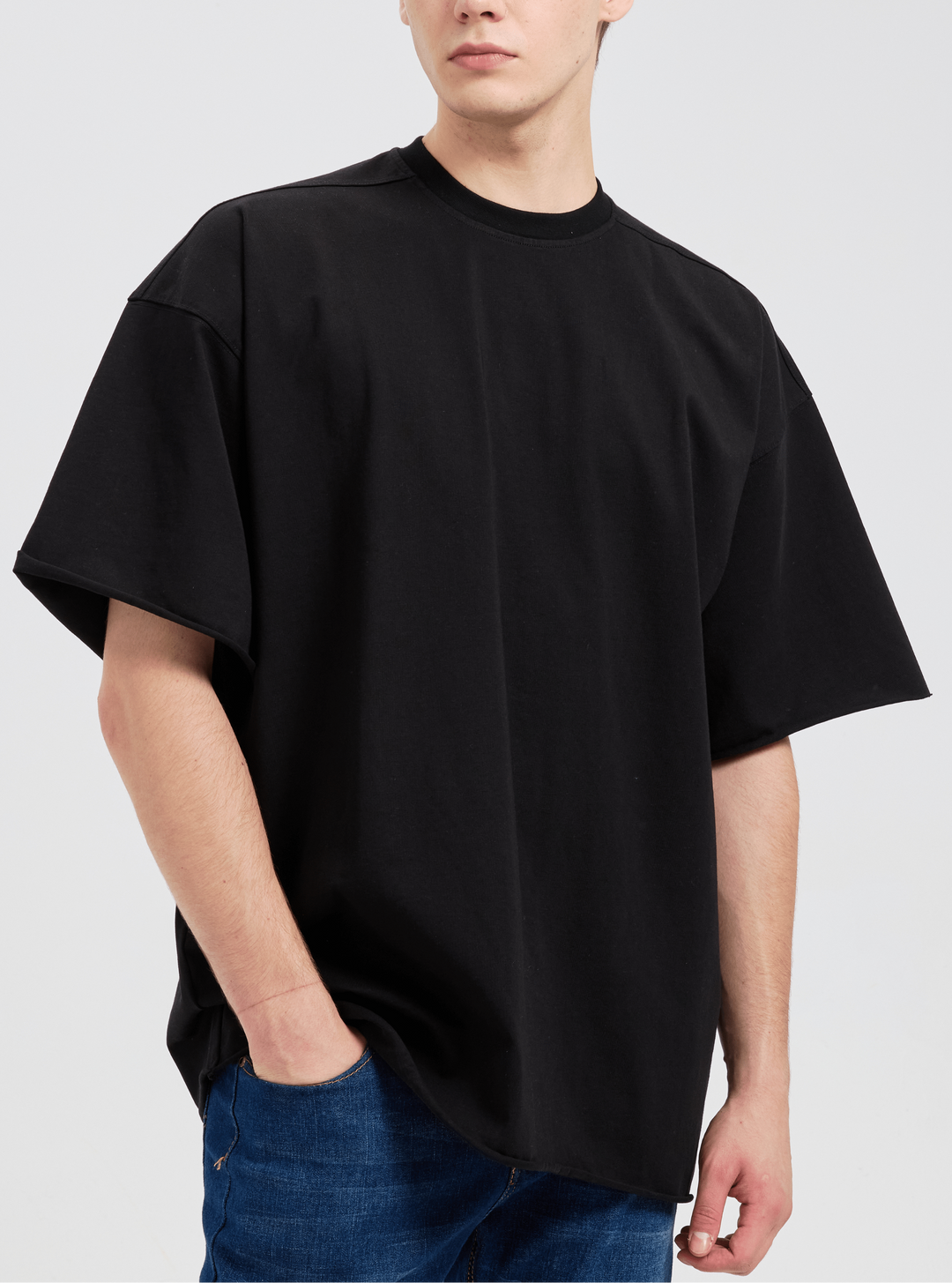Back view of a person wearing a plain blue oversized drop shoulder cotton tee, showing its relaxed silhouette.