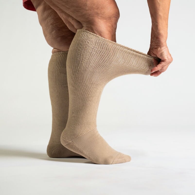 Close-up of a tan compression sock, highlighting its stretch fit and comfortable texture.