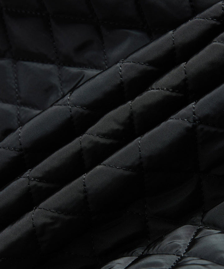 Man zipping up his black insulated sherpa-lined winter jacket, preparing for cold outdoor activities