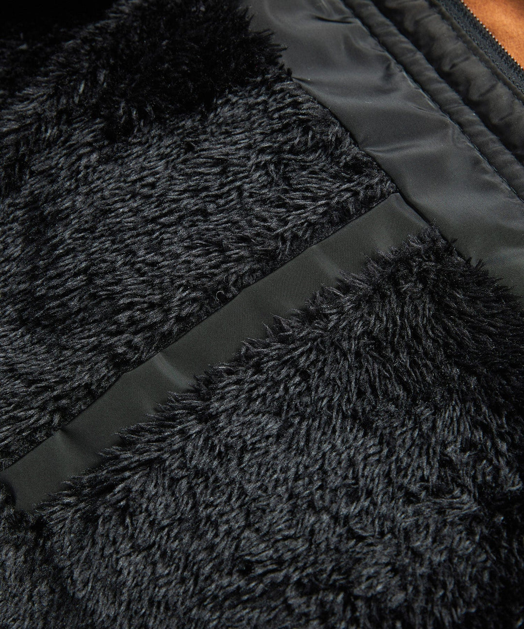Black men's insulated winter jacket laid flat, highlighting its sherpa lining and warm features