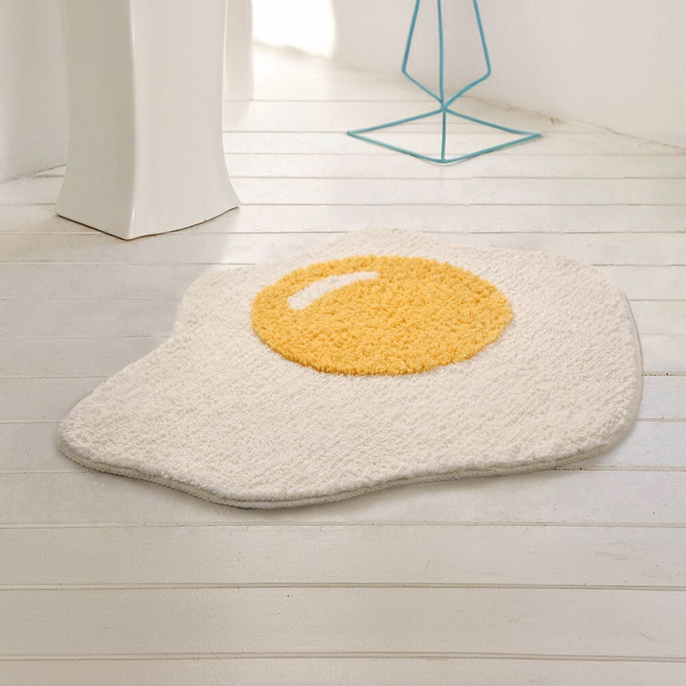 Soft shaggy fried egg bath mat for ultimate comfort. Playful, absorbent, and non-slip for bathroom or kitchen.