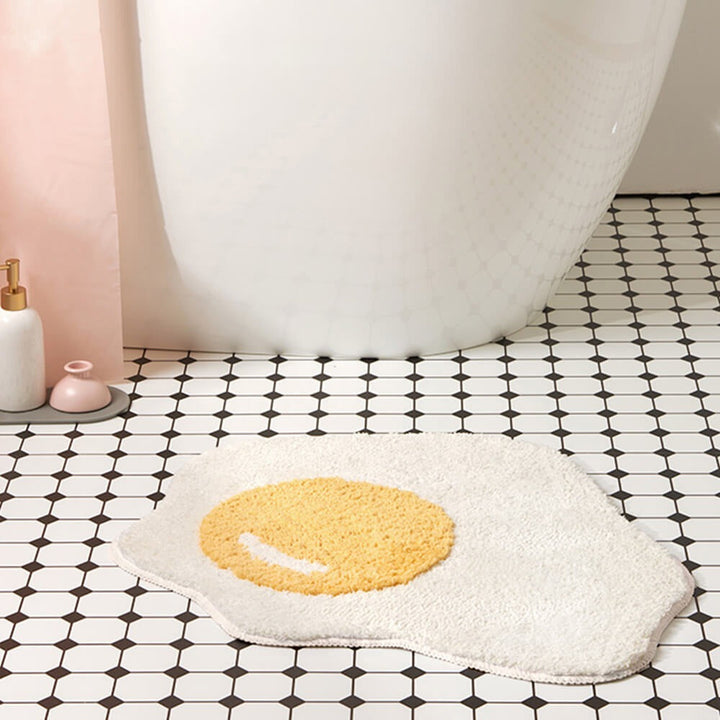 Unique fried egg bath mat, a soft shaggy rug for whimsical home decor. Absorbent, non-slip & machine washable.