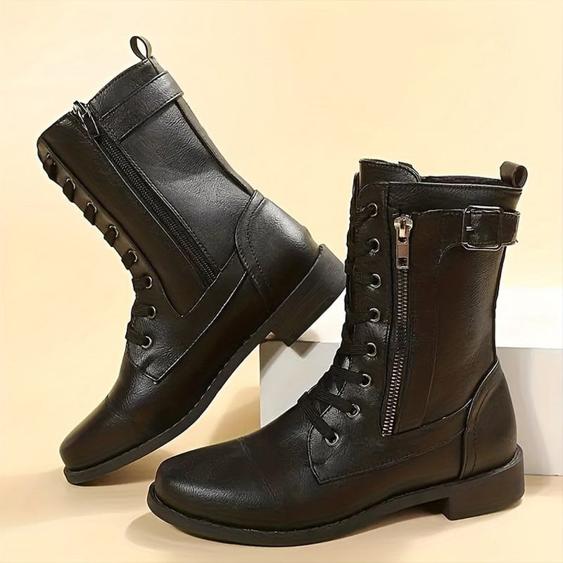 Studio shot of women's black combat boots, clean and detailed, showing all features including side zip.